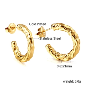 Détail de boucles d'oreilles C en acier doré 18K avec design torsadé et texture martelée