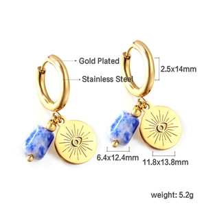 Détail des pierres marbrées bleues et des breloques œil en or sur boucles d'oreilles