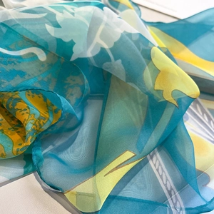 Floral print chiffon silk scarf in blue and yellow hues with soft artistic pattern