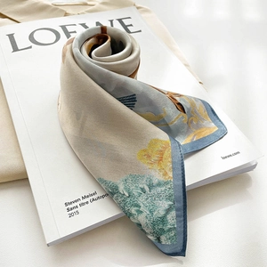 Detail of silk scarf with floral wing pattern on magazine backdrop with blue hem
