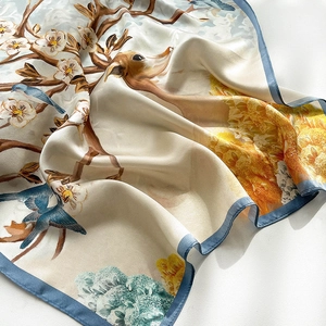 Detailed view of silk square scarf featuring traditional plum and deer printed patterns