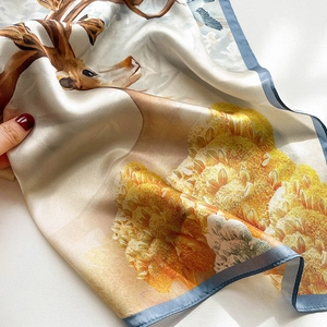 Detailed close-up of a floral silk scarf showing a realistic deer print and hemmed edges