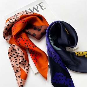 Close-up of silk scarf with abstract pop art leopard print and satin finish on magazine