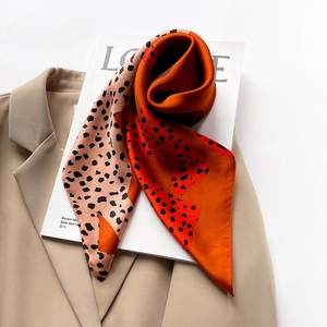 Detail of silk square scarf featuring leopard print on a beige blazer and magazine