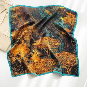 Detail of silk square scarf featuring artistic golden tree prints and teal blue edges