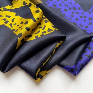 Detailed close-up of premium silk scarf featuring bold color blocks and abstract textures