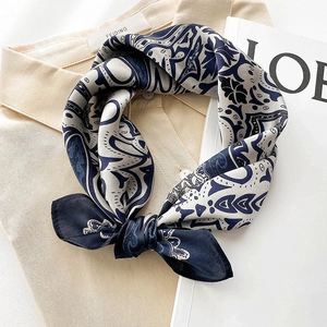 Elegant silk scarf with navy and beige paisley print tied on a minimalist shirt
