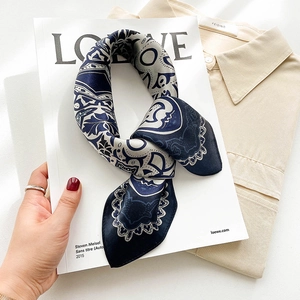 Close-up of navy and silver vintage print silk scarf on a white fashion magazine