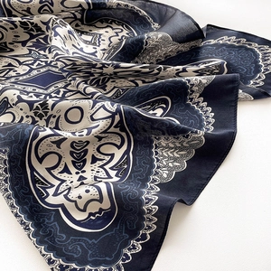 Detail of silk scarf showing vintage paisley patterns and smooth texture on white background