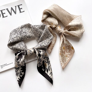 Detail of silk-texture floral scarves with elegant bows and smooth glossy finish