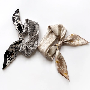 Detailed view of floral silk neckerchiefs with elegant abstract patterns and satin texture