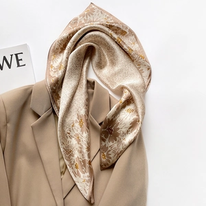 Elegant floral silk square scarf in beige and brown styled on a beige blazer