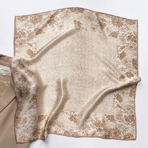 Detail of floral silk square scarf elegantly layered on a khaki blazer jacket