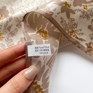 Close-up of silk scarf label showing 100% mulberry silk and 70x70cm dimensions