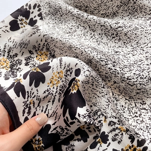 Detailed close-up showing the soft silk texture and floral pattern of the scarf scarf