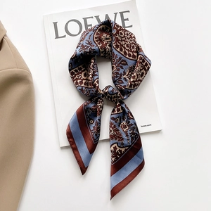 Elegant paisley silk skinny scarf for women in blue and brown, styled on a magazine