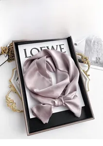 Detailed view of knotted lotus pink mulberry silk scarf with elegant glossy texture