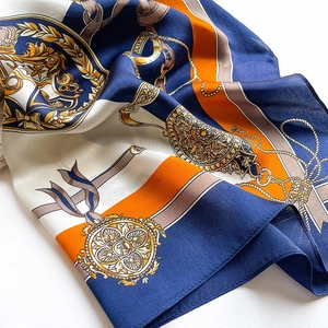 Macro shot of silk scarf showing equestrian chains and royal emblem patterns