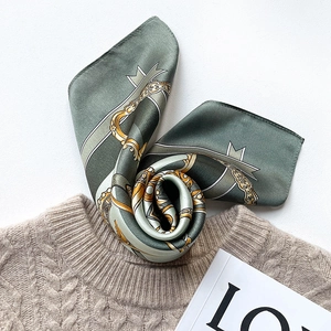 Green silk square scarf with vintage gold chain pattern on beige winter sweater