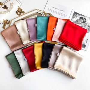 Flat lay of colorful silk square scarves in thirteen elegant shades for professional styling