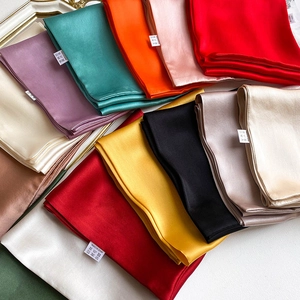 Macro view of multi-color silk scarves showing smooth texture and wash care labels