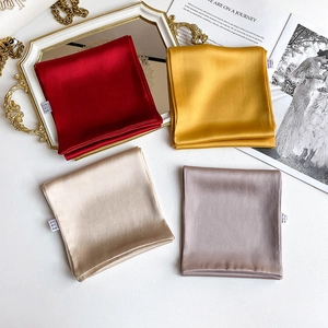 Flat lay of colorful satin silk scarves on an elegant tray with fashion magazines