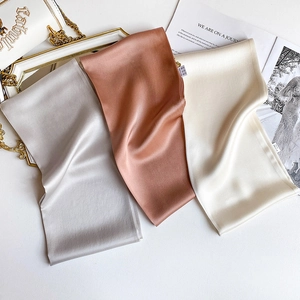 Detail of elegant silk scarves in silver, pink and cream with a luxury satin luster
