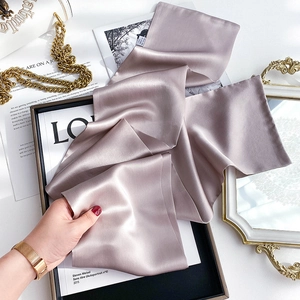 Detailed close-up of premium mulberry silk scarf in dust pink with elegant sheen