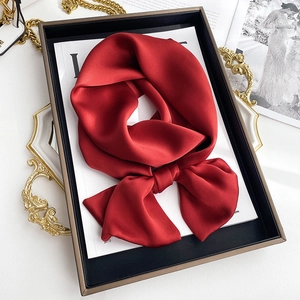 Elegant wine red satin silk scarf tied in a bow knot inside a luxury gift box