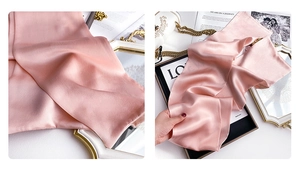 Macro shot of elegant pink silk scarf fabric showing smooth texture and pearly luster