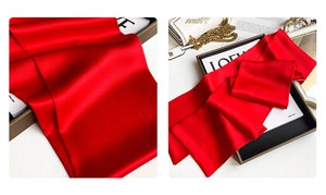 Detailed close-up of premium red silk scarf texture and elegant fashion layout