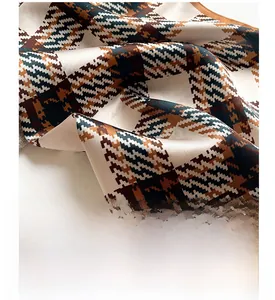 Macro detail of silk scarf showing digital plaid print and premium satin texture