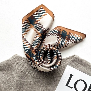 Elegant silk check square scarf in brown and teal placed on a soft grey sweater
