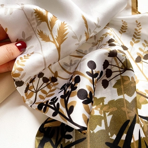 Detail shot of silk scarf showing luxurious texture and floral print with soft sheen