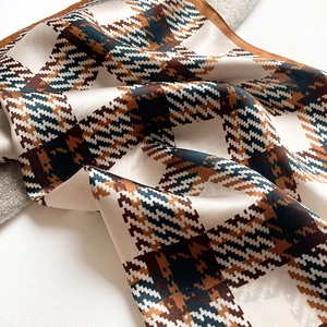 Detail of silk scarf showing classic houndstooth pattern and smooth satin texture