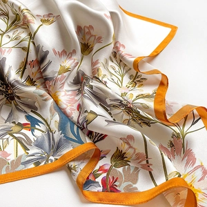 Detail of silk scarf showing floral prints and vibrant orange hand-rolled edges
