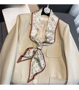 Detail of paisley print silk scarf tied on a beige blazer collar for styling