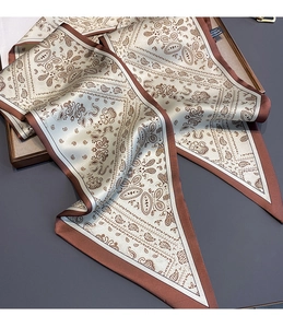 Detail of elegant paisley silk scarf with satin finish and decorative printed border
