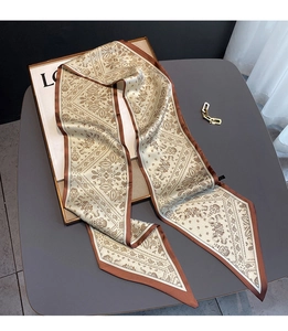 Detail of paisley print silk scarf displayed on a minimalist gift box packaging