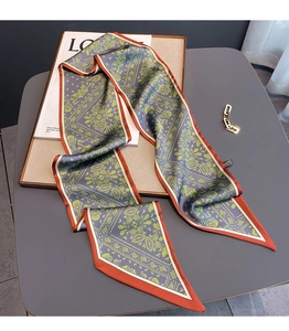 Detail of grey-blue paisley pattern silk scarf with orange border on a decorative frame