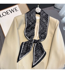 Detail showing paisley silk scarf tied on a beige suit collar for fashion styling