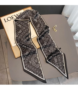 Close-up of black and white paisley print silk scarf used as a stylish headband or necktie