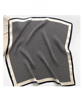 Détail macro du foulard en soie à motif géométrique avec bordure noire élégante
