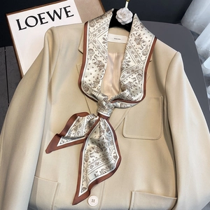 French style paisley silk scarf in tan and beige tied on a beige blazer collar