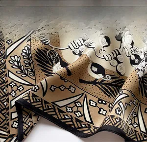 Macro detail of high-quality silk scarf showing fine edge stitching and floral patterns