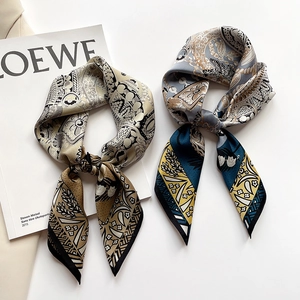 Printed silk scarf set featuring intricate paisley patterns and smooth satin texture