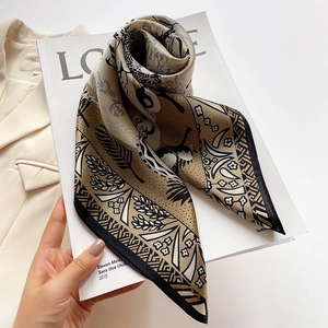 Elegant silk scarf with floral and geometric print in bronze tones on a beige blazer