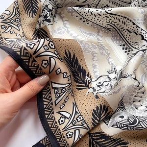 Close-up of printed silk scarf showing refined bohemian pattern and soft draped texture