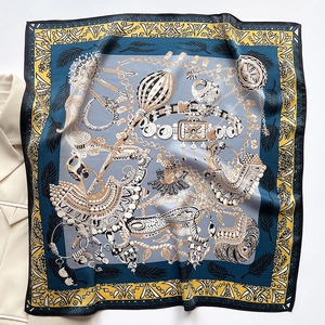 Detailed close-up of silk square scarf featuring vintage jewelry and chain patterns