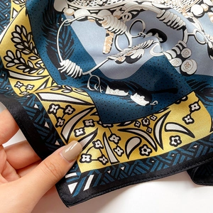 Close-up of soft printed silk square scarf showing delicate floral patterns and texture